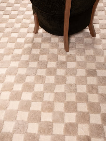 Checkered shearling rug with sheepskin wooden lounge chair