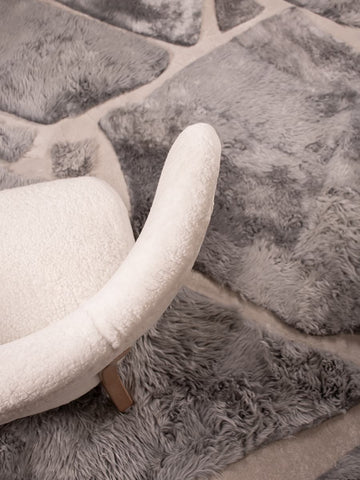Luxury shearling rug styled under modern boucle chair
