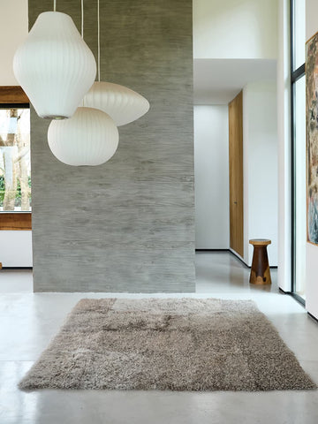 Homelosophy curly goatskin rug in silver grey styled in a minimalist living room