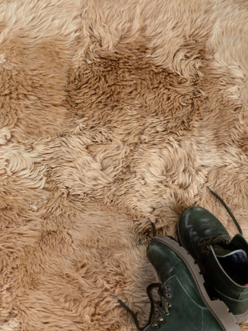 Beige camel lambskin rug with boots – cozy detail shot - Custom Sized Rugs from Homelosophy